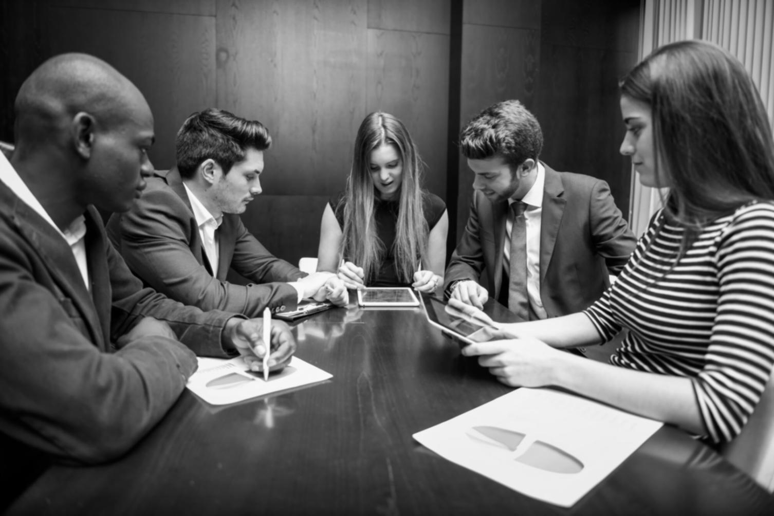 Equipo de consultores financieros revisando reportes y gráficos de rendimiento empresarial